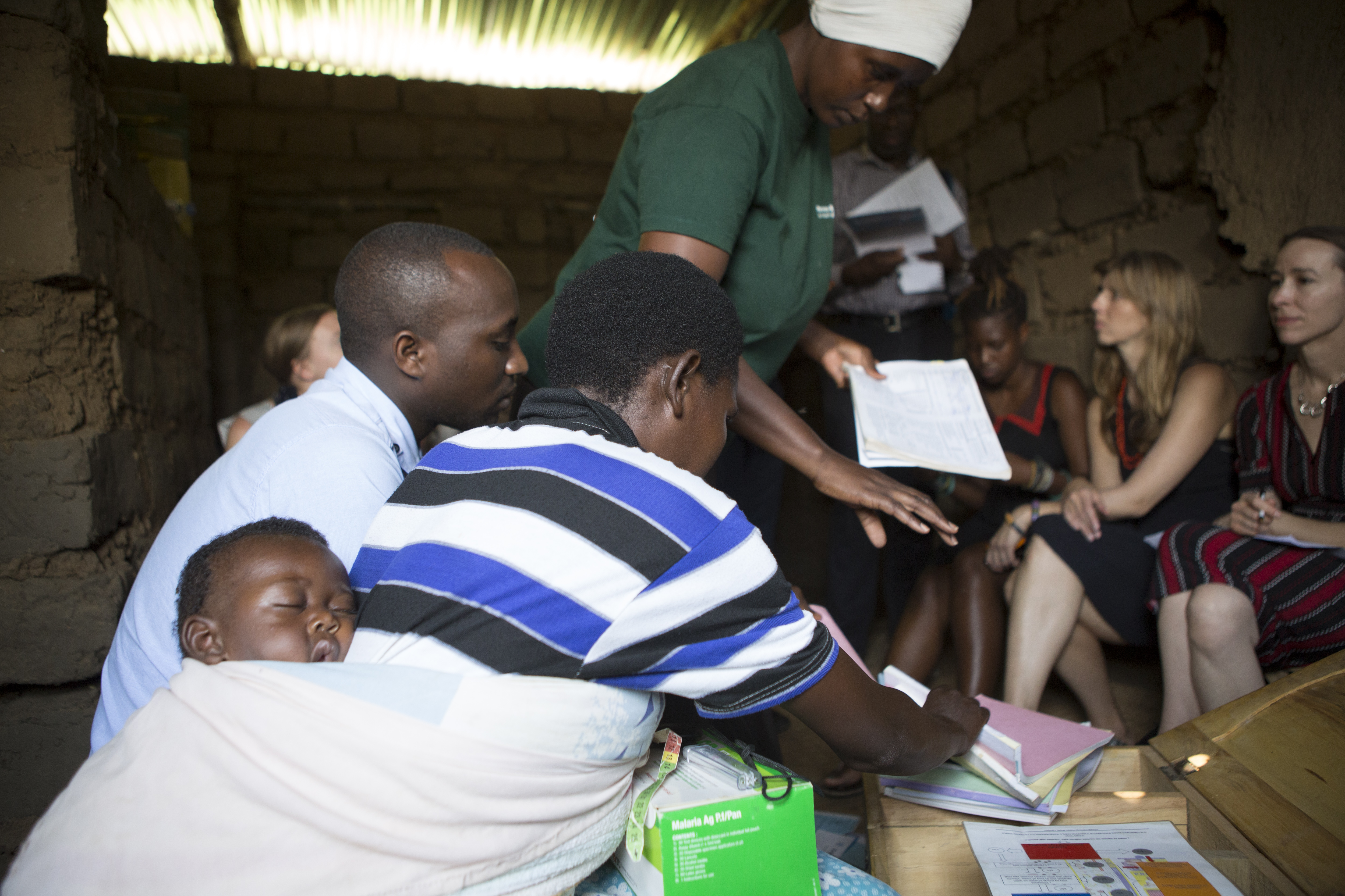 A community health worker walks students through her toolbox of patient logs, health assessments, and treatments.